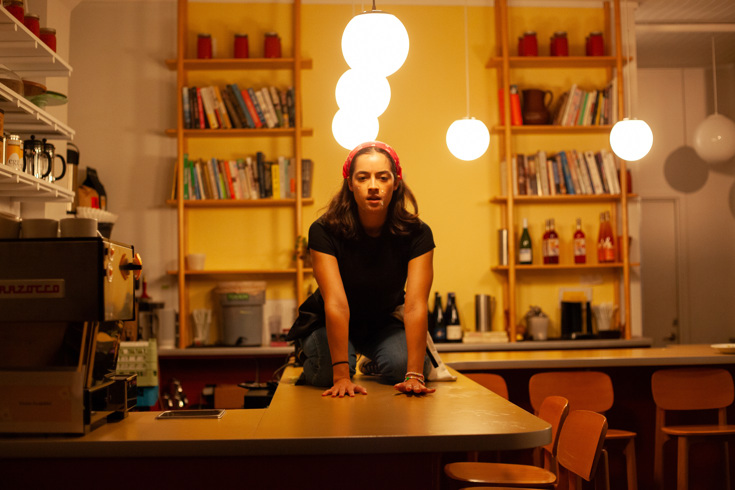 A woman learning on a table looking serious