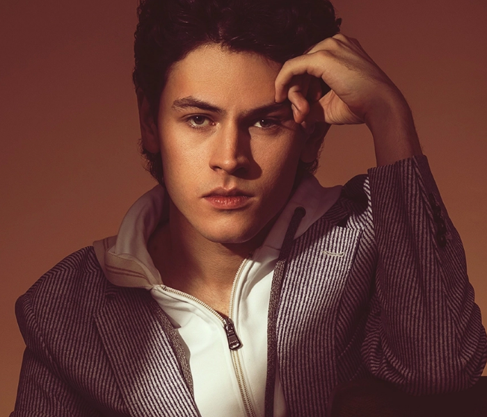 Close-up of Casey Likes looking serious with his right hand on his temple