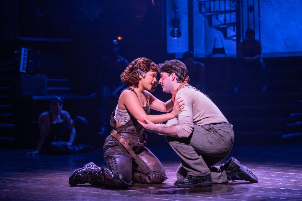 A young woman and man kneeling on the floor in an embrace