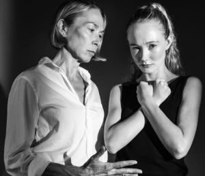 A black-and-white photo of Elizabeth Marvel and Elizabeth Yeoman looking sad and serious
