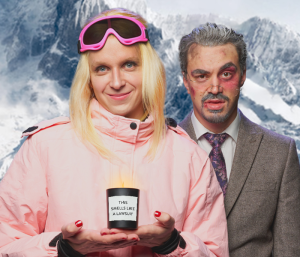 A performer playing Gwyneth Paltrow in pink ski gear next to a man in a gray suit with a black eye