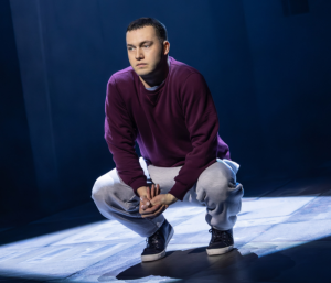A young man looking sad crouching on the ground