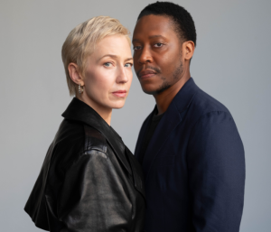 Carrie Coon and Namir Smallwood dressed in black and standing close together looking at the camera