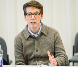 Sean Hayes sitting and talking with an intense look