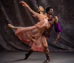 A female ballet dancer arching her back while a male dancer holds her