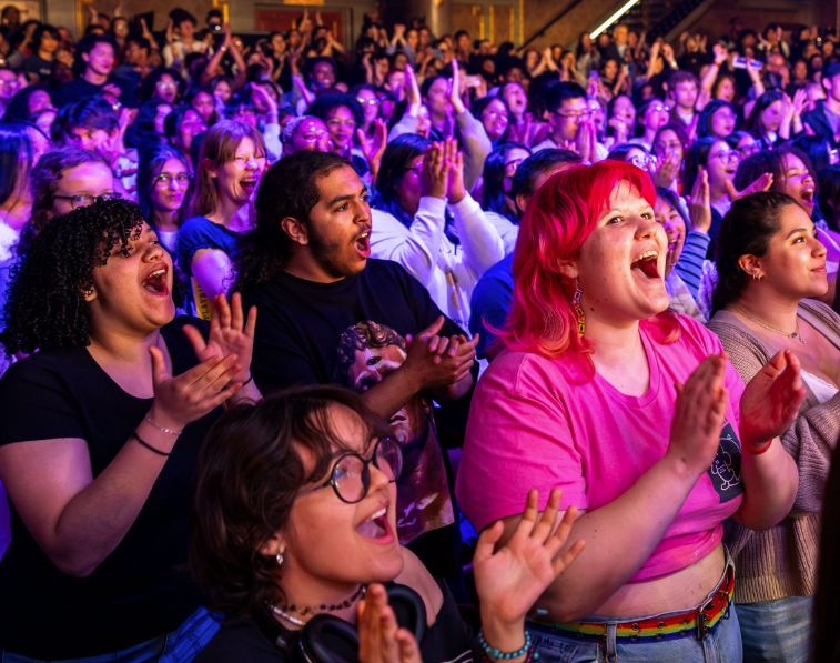 A diverse audience at the theatre cheering