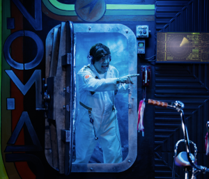 An astronaut in a space pod under blue light