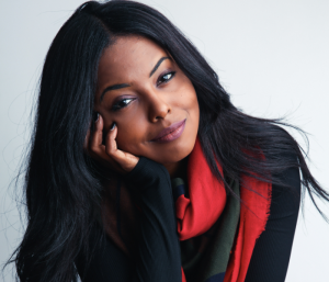 Adrienne Warren with her head to the side and a slight smile