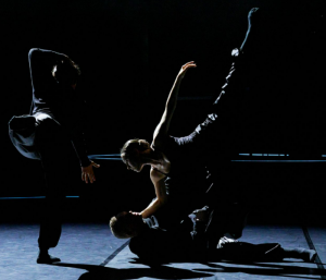 Three people dancing in silhouette